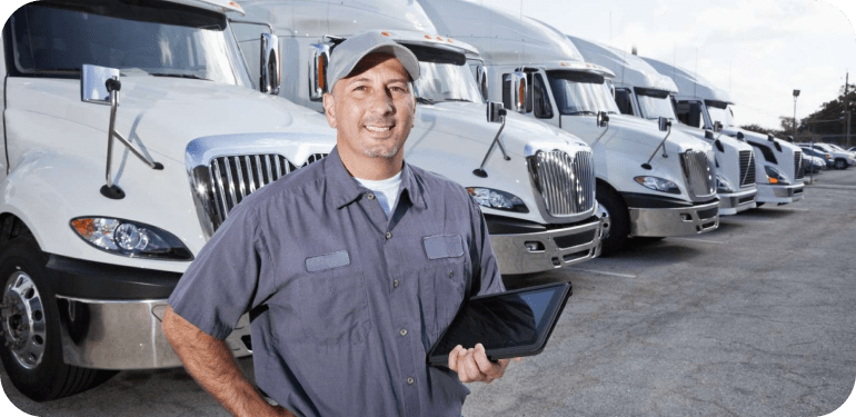 Driver standing near fleet trucks